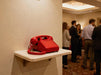 Red vintage telephone on a wall shelf at an indoor business event