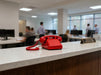 Red retro telephone on office reception desk in professional workplace setting