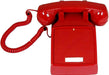 Red vintage wall telephone with corded handset on white background
