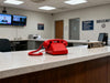 Red vintage push button corded telephone with handset, coiled cord, and large number keypad.