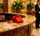 Red vintage corded telephone on luxury hotel reception desk with marble counter.